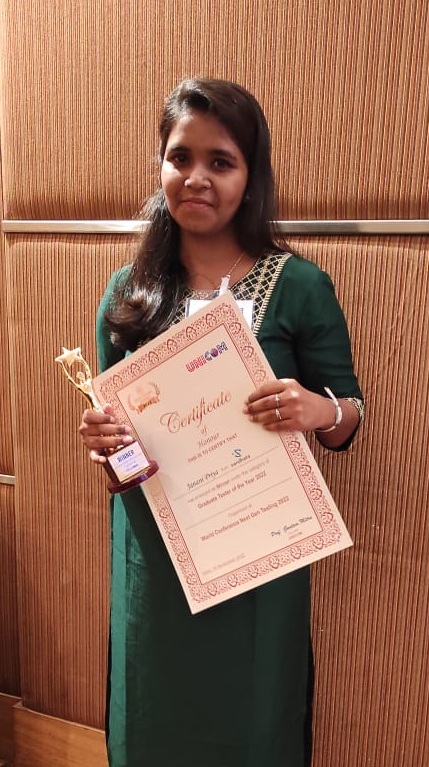Janani Priya holding her certificate and award